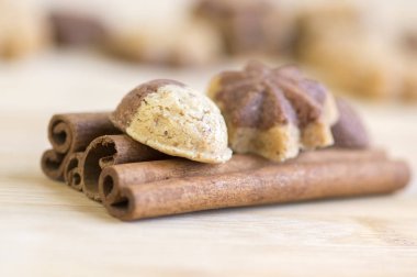 Tarçın sandbakelse Noel kurabiyeleri, iki renkli, koyu kahverengi kakao ve vanilya altın kahverengi, tarçın ham kabuk baharat, yıldız ve fındık şekiller üzerinde ahşap arka plan ışık