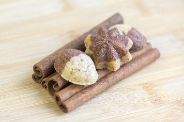 Tarçın sandbakelse Noel kurabiyeleri, iki renkli, koyu kahverengi kakao ve vanilya altın kahverengi, tarçın ham kabuk baharat, yıldız ve fındık şekiller üzerinde ahşap arka plan ışık