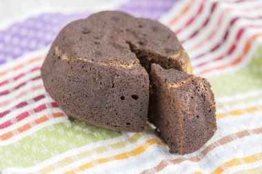 Beyaz renkli mutfak havlusu tabakta, lezzetli tatlı koyu kahverengi bisküvi ışığında çikolatalı kek