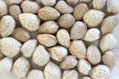 Nutshells hafif kahverengi ahşap masa, badem arka plan üzerinde kahverengi badem