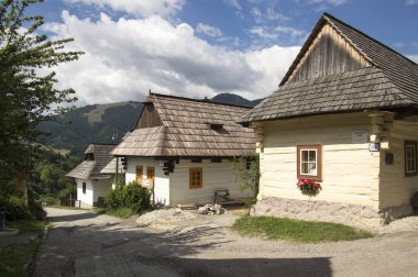 Güzel Vlkolinec geleneksel köy Slovakya ahşap kulübe, halk evleri, Velka Fatra dağlar, güneşli hava, mavi gökyüzü, beyaz bulutlar