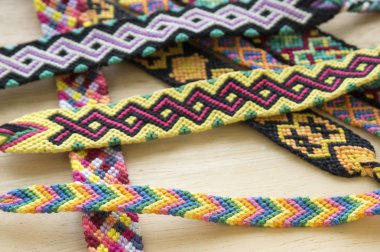 El yapımı ev yapımı renkli doğal dokuma dostluk bilezik ahşap masa, moda aksesuar grubu, çeşitli renkler üzerinde Grup