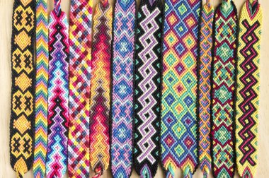 El yapımı ev yapımı renkli doğal dokuma dostluk bilezik ahşap masa, moda aksesuar grubu, çeşitli renkler üzerinde Grup