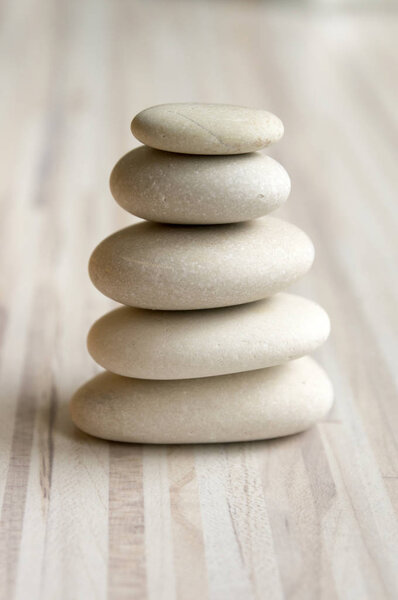 Harmony and balance, cairn, poise stones on striped table, rock zen sculpture, white and grey pebbles
