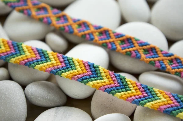 Freundschaftsarmbänder Bunte Gewebte Freundschaftsarmbänder Auf Weißen Kieseln Weißen Meereskieselsteinen Regenbogenfarben — Stockfoto