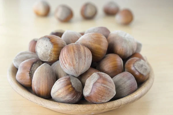 木盘桌上的花冠坚果 壳中常见的淡褐色坚果组 — 图库照片