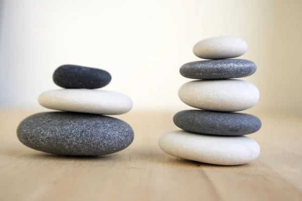 和谐与平衡 木桌上的稳重石头 岩石禅宗雕塑 五块深灰色和白色的鹅卵石 两种颜色 黑色和白色 — 图库照片
