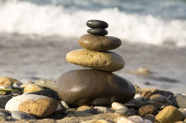 stock image Harmony and balance, poise brown and black stones against the sea, rock zen sculpture, sunny day