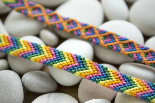 Freundschaftsarmbänder Bunte Gewebte Freundschaftsarmbänder Auf Weißen Kieseln Weißen Meereskieselsteinen Regenbogenfarben — Stockfoto