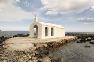 Saint Nicholas küçük kilise, denizde taşlar ve kayalar, Georgioupolis kasaba, Crete island, Yunanistan, bulutlar, mavi gökyüzü, güneşli, turistik ilgi noktası, cazibe üzerinde terk şaşırtıcı beyaz Şapel