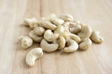 Ahşap masa, basitlik, gün ışığı, sağlıklı fındık üzerinde kahverengi kaju fıstığı döktüm