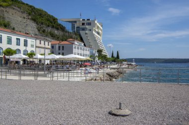 Piran, Portoroz / Slovenya - 24 Haziran 2018: insanlar, lokanta ve oteller, sahil şeridine güzel yaz günü güneş ve mavi gökyüzü