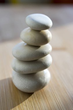 Uyum ve denge, dengeli taşlar üzerinde ahşap masa, zen heykel rock