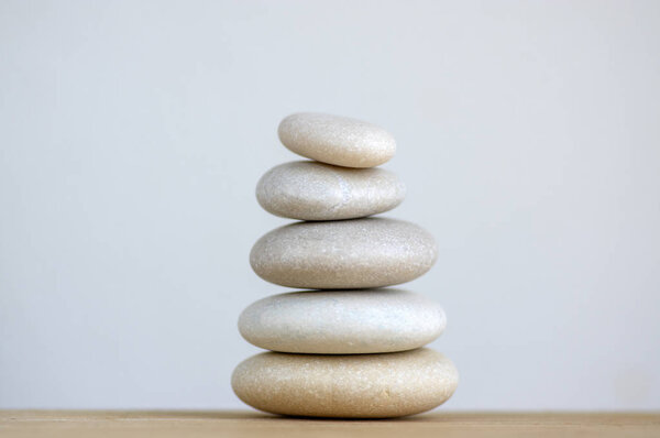 Harmony and balance, cairns, simple poise stones on white background, rock zen sculpture, five white pebbles, single tower, simplicity