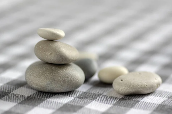 Harmony and balance, cairns, simple poise stones on white gray checkered background, rock zen sculpture, white pebbles