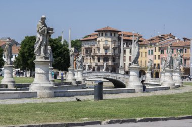 Padua / ITALY - June 12, 2017: Beautiful summer day on Prato della Valle square with water canal. Amazing italian sculptures. clipart