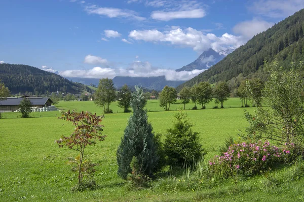 Rakouská Verfenveg vesnice Alpy hory podzimní krajina s mlhou, zelené louky a skály — Stock fotografie