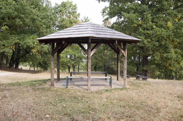Simplicity wooden shelter with seats in nature, small gazebo for tired tourists — Stock Photo, Image