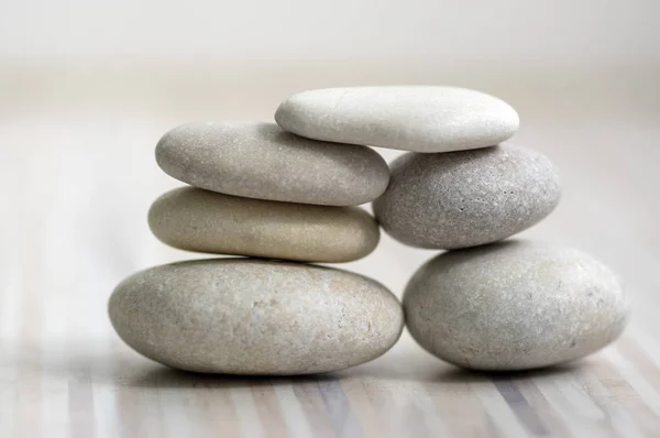 Harmonia e equilíbrio, cairns, pedras de equilíbrio simples sobre luz de madeira fundo cinza branco, simplicidade escultura zen rocha — Fotografia de Stock