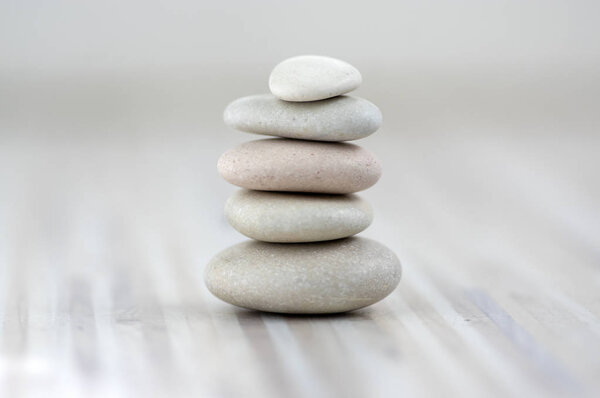 Harmony and balance, cairns, simple poise stones on wooden light white gray background, simplicity rock zen sculpture