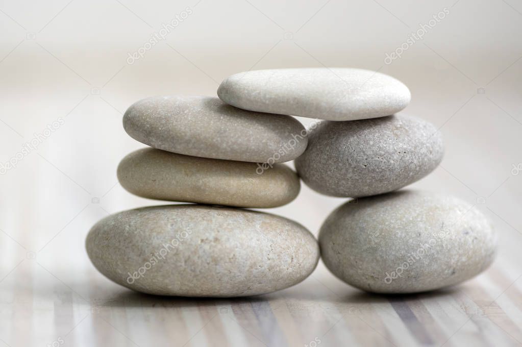 Harmony and balance, cairns, simple poise stones on wooden light white gray background, simplicity rock zen sculpture