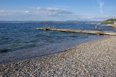 Izola / Slovenya - 23 Haziran 2018: Taş Sahilde harika yaz gününün tadını çıkaran insanlar.