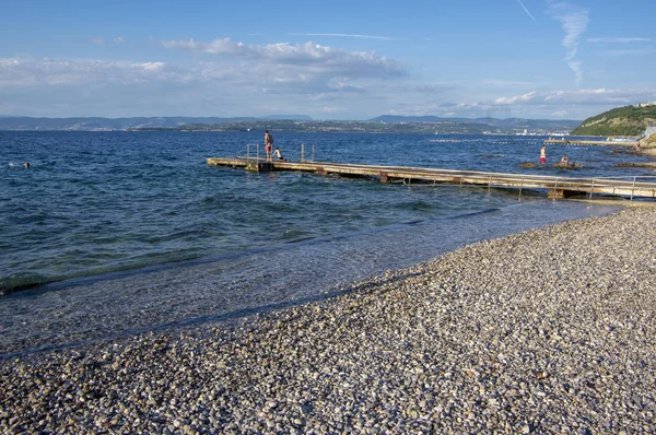 Izola / Slovenya - 23 Haziran 2018: Taş Sahilde harika yaz gününün tadını çıkaran insanlar.