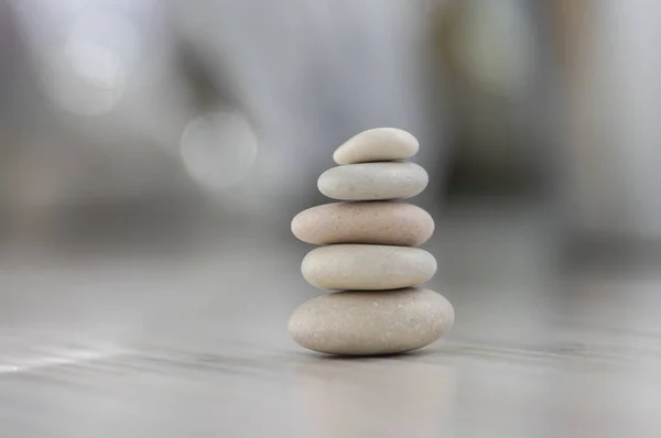 Harmonie et équilibre, cairns, cailloux simples poise sur fond gris clair en bois, simplicité rock zen sculpture — Photo