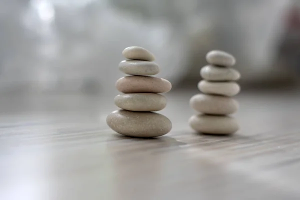 Armonia ed equilibrio, due cairn, semplici ciottoli di portamento su fondo grigio chiaro bianco legno, scultura zen rock semplicità — Foto Stock