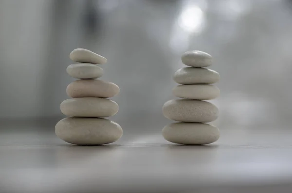 Armonia ed equilibrio, due cairn, semplici ciottoli di portamento su fondo grigio chiaro bianco legno, scultura zen rock semplicità — Foto Stock