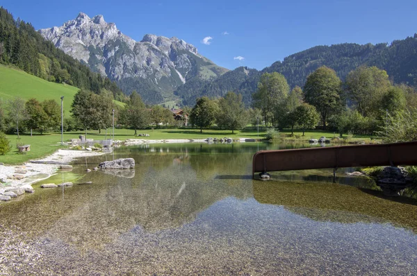 Veřejné biotopové jezero ve Verfenwengu obklopené Alpami, nádherné skály v odrazu vodní hladiny, úžasná zeleň — Stock fotografie