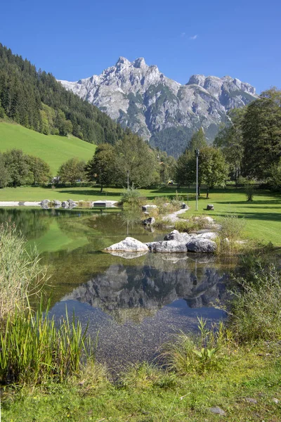 Veřejné biotopové jezero ve Verfenwengu obklopené Alpami, nádherné skály v odrazu vodní hladiny, úžasná zeleň — Stock fotografie