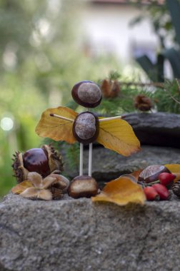 Bahçede kestane ve güvenlik kibritleri ve kuru yapraklardan yapılan melek ve şeytan figürleri
