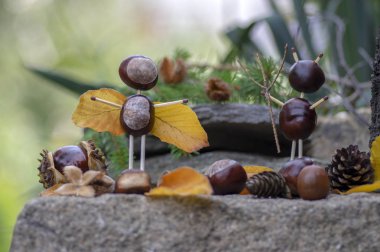 Bahçede kestane ve güvenlik kibritleri ve kuru yapraklardan yapılan melek ve şeytan figürleri