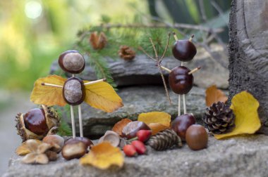 Bahçede kestane ve güvenlik kibritleri ve kuru yapraklardan yapılan melek ve şeytan figürleri