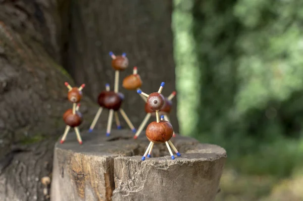 Grupo de animais de castanha engraçados no toco da árvore, fundo verde, artesanato tradicional de outono, cervos ovinos europeus com família — Fotografia de Stock