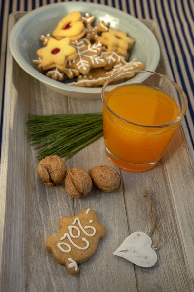 Christmas breakfast on wooden tray, fresh orange juice gingergread, shortcrust pastry cookies and pour feliciter pig 2020