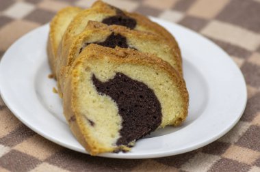 Gugelhupf piknik battaniyesinde beyaz tabak, çok lezzetli iki renkli Çek pastası, adı babovka, yemeye hazır.