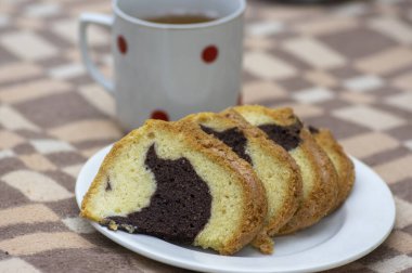 Gugelhupf piknik battaniyesinde beyaz tabak, çok lezzetli iki renkli Çek pastası, adı babovka, yemeye hazır.