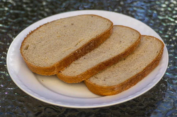 Slices of simple wheat bread on white plate, ready to eat, food and drink — Stock Photo, Image