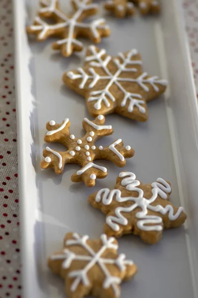 Накрашенные традиционные рождественские пряники, приготовленные на белом блюде при дневном свете, пунктирная скатерть, общие чешские вкусные сладости — стоковое фото