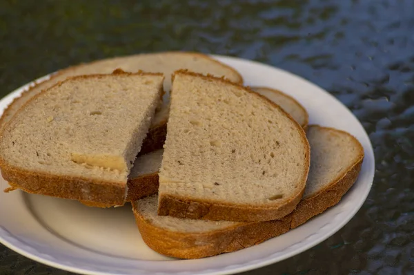 Tranches de pain de blé simple sur assiette blanche, prêtes à manger, aliments et boissons — Photo