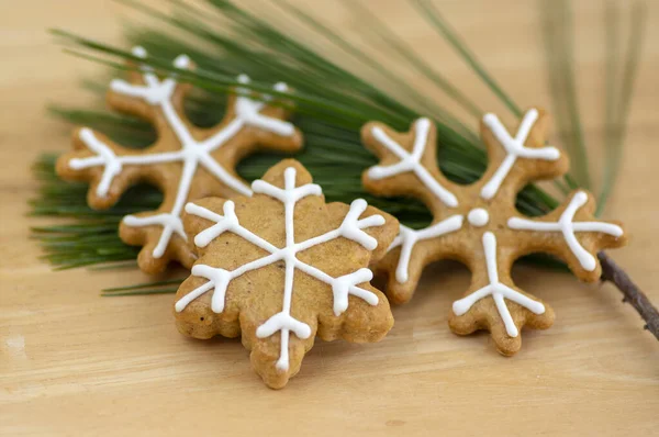 Bemalte traditionelle Weihnachts-Lebkuchen auf hölzernem Hintergrund bei Tageslicht, übliche leckere Süßigkeiten auf Tannennadeln — Stockfoto