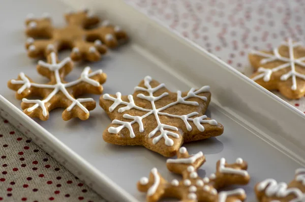 Накрашенные традиционные рождественские пряники, приготовленные на белом блюде при дневном свете, пунктирная скатерть, общие чешские вкусные сладости — стоковое фото