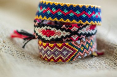 El yapımı, renkli, doğal, dokuma bilezikler jüt arka planda izole edilmiş arkadaşlık bilezikleri.