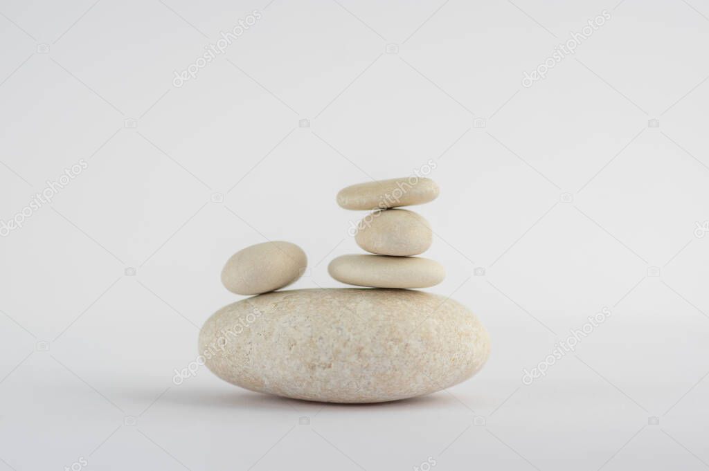 One simplicity stones cairn isolated on white background, group of five white pebbles in tower, harmony and balance