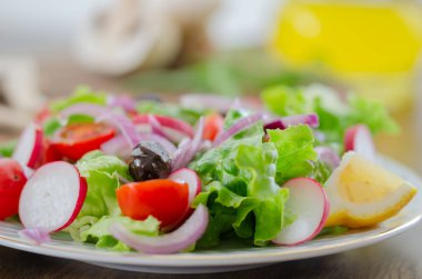 Beyaz plaka üzerinde taze karışık sebze salatası. Seçici odak