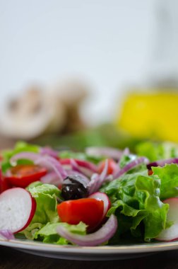 Beyaz plaka üzerinde taze karışık sebze salatası. Seçici odak