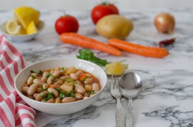 Beyaz bir kase, closeup havuç kırmızı barbunya fasulyesi domates soslu. Üstten yatay görünüm