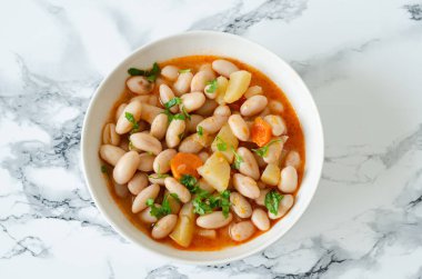 Beyaz bir kase, closeup havuç kırmızı barbunya fasulyesi domates soslu. Üstten yatay görünüm